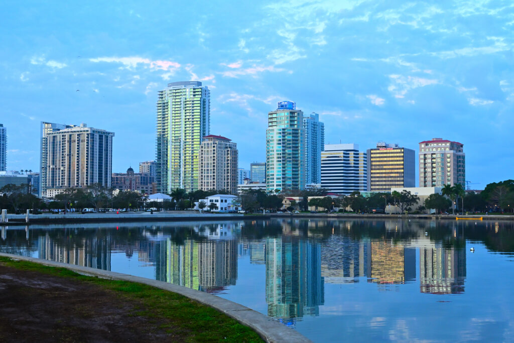 The skyline of St Petersburg FL at sunrise, featuring water in the foreground